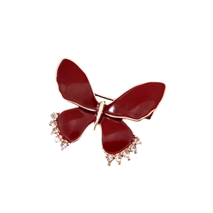 Vintage red butterfly brooch with gold edges and sparkling rhinestones on white backdrop