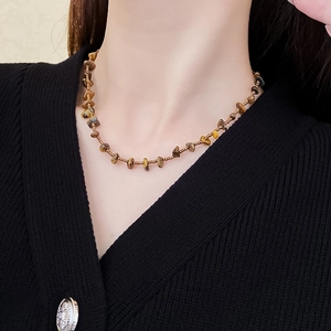 Brown tiger eye stone beaded necklace worn on neck for a vintage bohemian fashion style