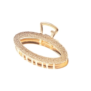 Minimalist gold metal hair claw clip with oval textured design and polished finish