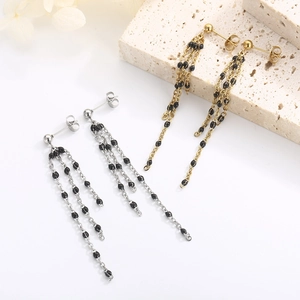 Detail shot of long tassel earrings with black resin beads in gold and silver finish