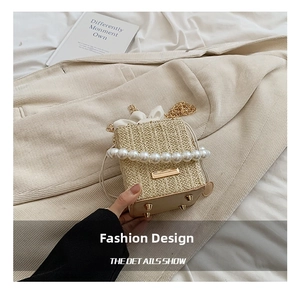 Detail of woven straw bag with pearl accents and gold metal protective feet on base