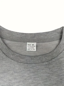 Macro shot of grey crew neck collar and size M label on high-quality polyester blend shirt