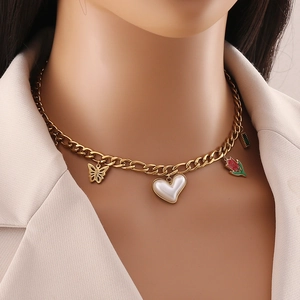 Gold chain necklace with butterfly, white heart, and red flower pendants on a model