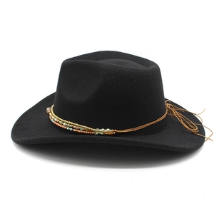 Close-up of black felt western cowboy hat with colorful beaded band and woven trim details
