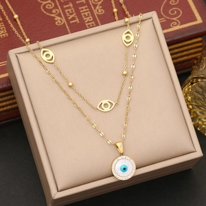 Detail of gold double-layered necklace featuring evil eye charms and cubic zirconia