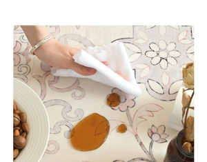 Close-up of easy-clean vintage floral rug with hand wiping away liquid spill with towel