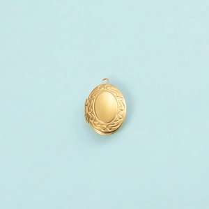 Pendentif médaillon ovale doré avec gravures de rinceaux sur un fond bleu clair épuré