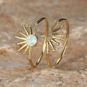 Macro shot of sunrise opal ring with radial design and golden finish on stone background