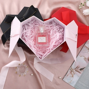 Macro detail of heart-shaped gift boxes with silk ribbons and paper filler inside