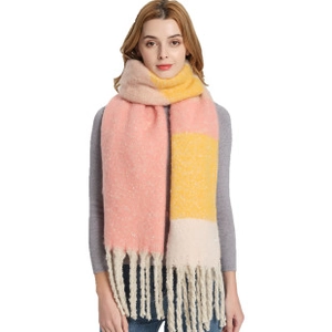 Detail of soft thick knit scarf with chunky tassels in pink, yellow and beige plaid