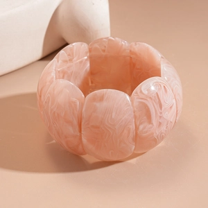 Detailed close-up of marble pattern acrylic stretch bracelet in peach pink and white tones