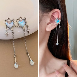 Vue détaillée des boucles d'oreilles cœur argenté avec pompons et mannequin portant le clip