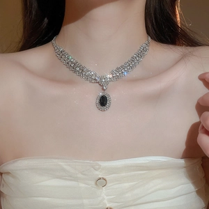 Close-up of vintage oval black zircon pendant with multi-row diamond-set V-chain