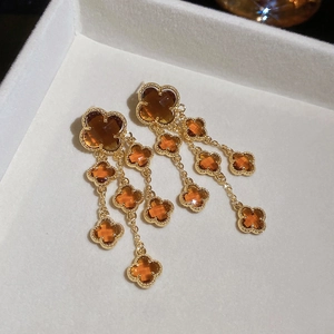 Detail of gold plated flower tassels earrings with amber crystal in jewelry box