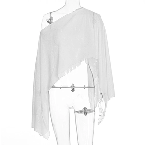 Detail view of white asymmetrical knit shawl featuring sheer fabric and drop shoulder design