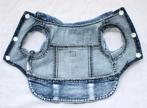 Detailed close-up of blue denim pet vest with white metal snaps and reinforced stitching