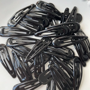 Classic black teardrop snap hair clips in a stacked set on a clean white background