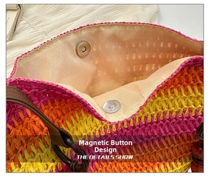 Detail of magnetic snap closure on rainbow striped woven straw bag with fabric lining