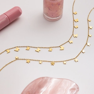 Detail of 18K gold stainless steel necklaces with butterfly and star star pendants