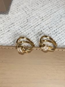Detailed view of gold-plated knot hoop earrings with micro-pave cubic zirconia accents