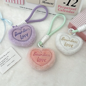Detailed view of heart-shaped plush charms with Boundless Love embroidery in soft colors