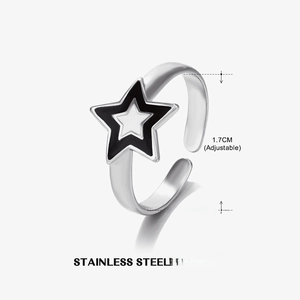 Detail view of star-shaped stainless steel ring with black and white enamel and adjustable band