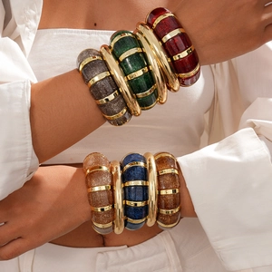 Chunky acrylic glitter bangles with gold metal spacers in a bohemian stacked bracelet set
