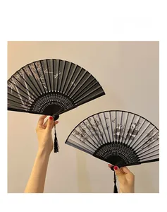 Detail of traditional ink painting folding fans with black bamboo ribs and long silk tassels
