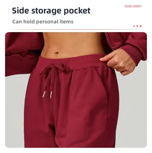 Detail of burgundy sweatpants with drawstring waist and functional side pockets