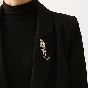 Sparkling leopard brooch with emerald eyes and black crystals on a black suit lapel