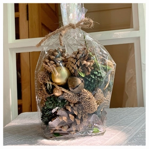 Pink and silver DIY Christmas pinecone kit with decorative gold balls in a rustic hemp bag