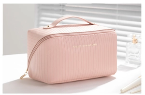 Detailed view of large pink cosmetic bag with vertical texture and gold double zipper
