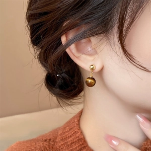 18k gold plated tiger eye stone drop earrings worn by a model in a side view