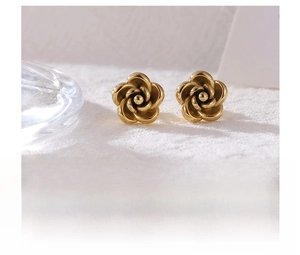 Macro detail of gold-plated titanium steel earrings in a vintage floral rose design