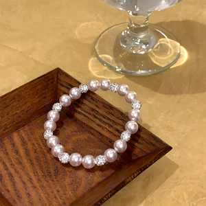 Gros plan d'un bracelet de perles lavande élégant avec perles argentées en strass