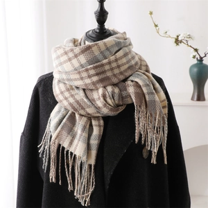 Detailed close-up of plaid cashmere-like scarf with fringe on a mannequin