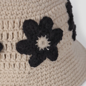 Gros plan sur un chapeau cloche beige au crochet avec motif floral et texture