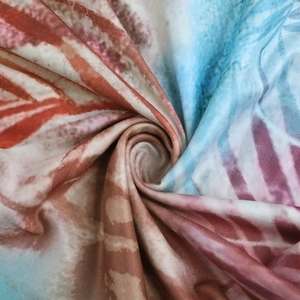 Detailed view of soft tropical leaf print fabric with gathered texture and draping