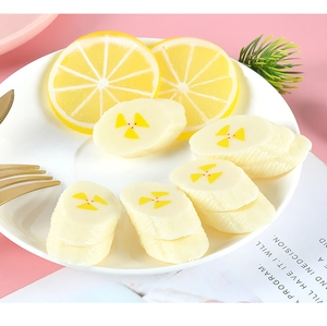 Detailed view of realistic PVC banana and lemon slices on a white decorative plate
