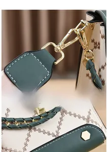Détails des crochets dorés et bords en cuir vert sur un sac à chaîne brodé élégant