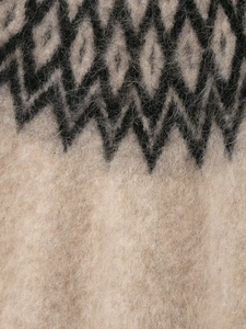 Dettaglio di tessuto in maglia con fibre di alpaca e motivi a onde nordiche nere