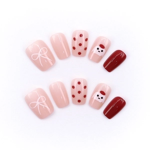 Cute red polka dot press-on nails with white bows and cartoon bear designs