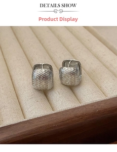 Macro shot of silver square hoop earrings with a unique hammered metal texture finish