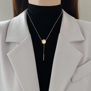 Minimalist Y-shaped gold necklace featuring a Roman numeral pendant and metal bar tassel