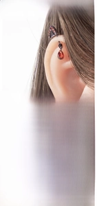 Macro detail of black gothic cat ear earplug with red zircon and 2.17cm size specs