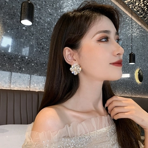 Macro shot of a sparkling crystal flower earring on model highlighting luxurious details