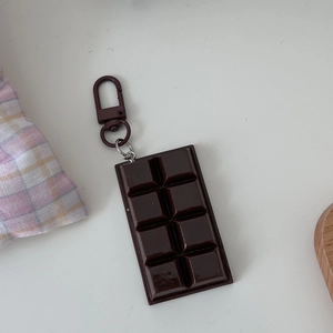 Detailed top view of a realistic chocolate bar keychain charm with a checkered fabric background