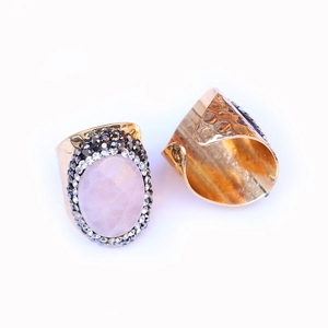 Detail view of the hammered gold band and oval pink gemstone with sparkling side stones