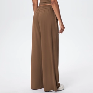 Rear view of brown high-waisted wide leg pants featuring elastic gathered waistband