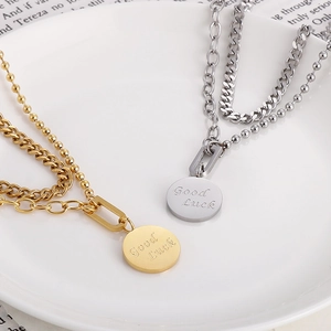 Dettaglio di collane a doppio strato in acciaio inossidabile oro e argento con ciondolo Good Luck